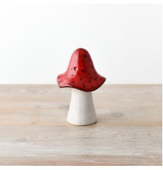 A vibrant red ceramic mushroom sure to add a whimsical touch to any space.  