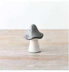 A small decorative ceramic grey mushroom that is sure to add a touch of whimsy to any home space.