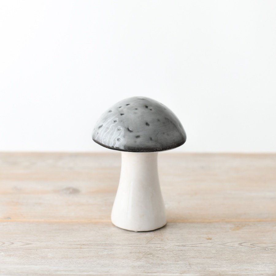 A whimsical ceramic mushroom featuring a grey glazed top