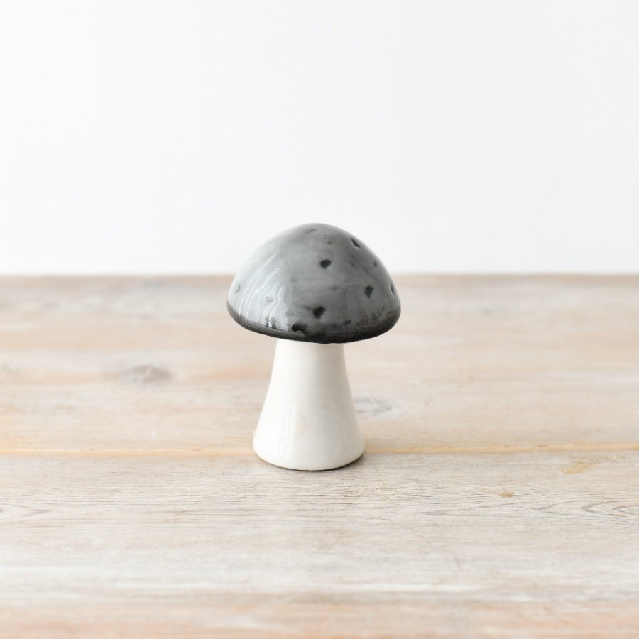 A delightful and whimsical ceramic mushroom with a glazed grey top.