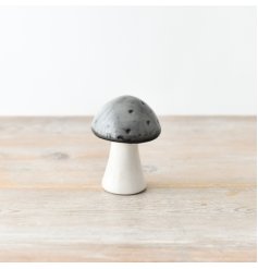A delightful and whimsical ceramic mushroom with a glazed grey to