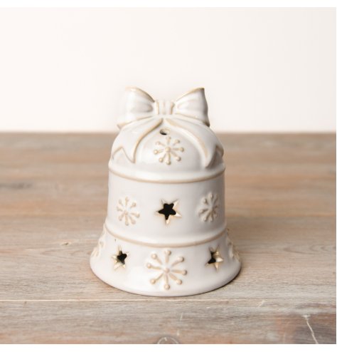 An exquisite festive LED bell in a beautiful white reactive glaze adorned with snow decals and star-shaped cutouts.