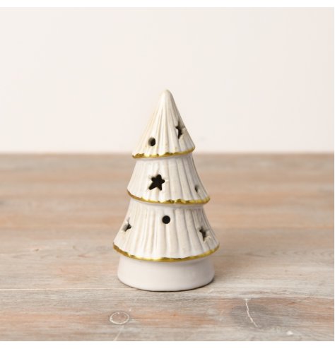 An enchanting LED tree featuring a natural white glaze, gold trim, and detailed star and dot cutouts.