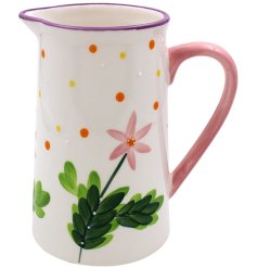 A glazed jug with embossed beading and a polkadot and floral pattern. 