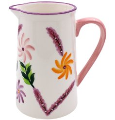 A small jug featuring bright flowers and leaves.