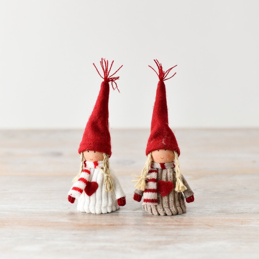 A charming pair of sitting girl dolls, each wearing coordinated red, white, and brown outfits