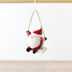 A charming ceramic Santa on a swing, featuring a jute string for easy hanging.