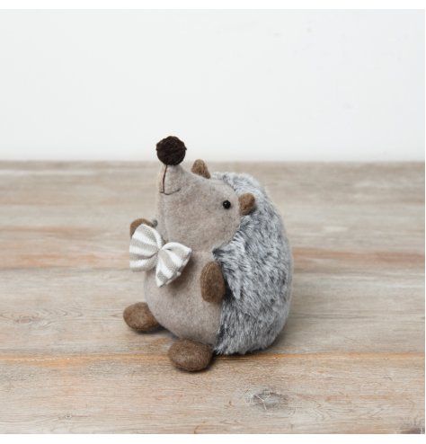 A delightful plush hedgehog adorned with a striped neutral bow and a fluffy grey back.