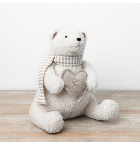 A charming soft ornament featuring a sherpa polar bear, adorned with a neutral scarf and holding a heart.