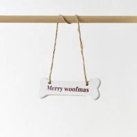 A delightful ceramic bone ornament embellished with the quote "Merry woofmas" in a vibrant red font.
