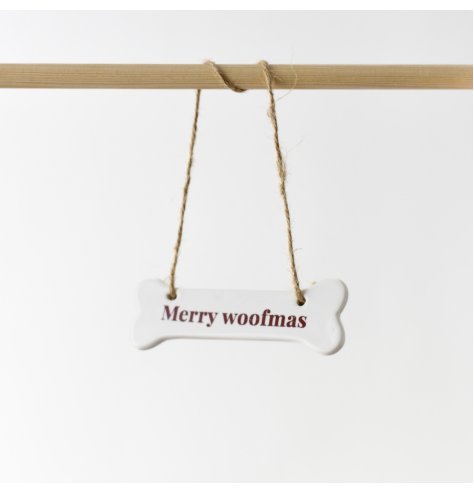 A charming ceramic bone hanger adorned with the quote "Merry woofmas" in a rich red font.