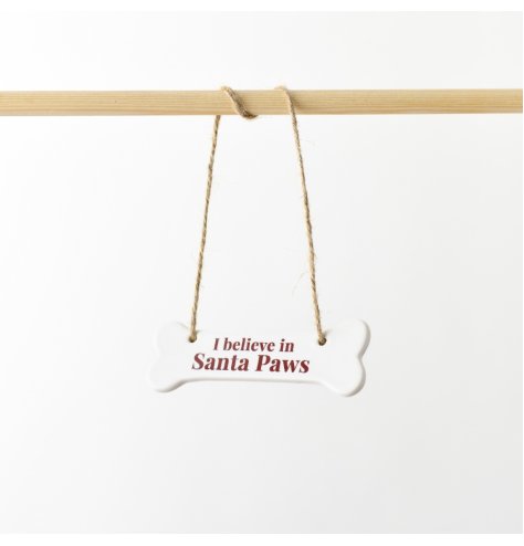 A delightful ceramic hanger crafted in the form of a bone, showcasing the expression "I Believe in Santa Paws"