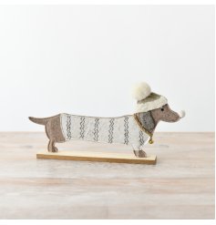 A charming felt dachshund ornament adorned with a winter jumper and bobble hat,