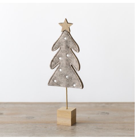 A neutral felt freestanding tree decoration set on a wooden block, detailed with polkadots and a wooden star at the top