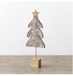 A simplistic felt freestanding Christmas tree in a natural colour tone with polkadots, set on a wooden base. 