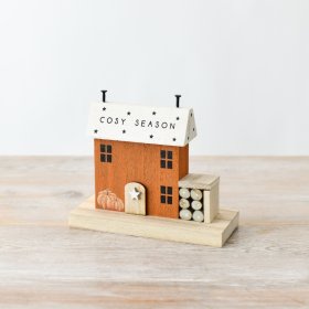 A charming wooden house ornament with a COSY SEASON slogan and 3D features. 