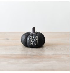 Spooky black pumpkin ornament with the words 'Trick or Treat' engraved with white text.