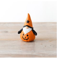 A spooky little gonk ornament dressed as a Jack-O-Lantern pumpkin