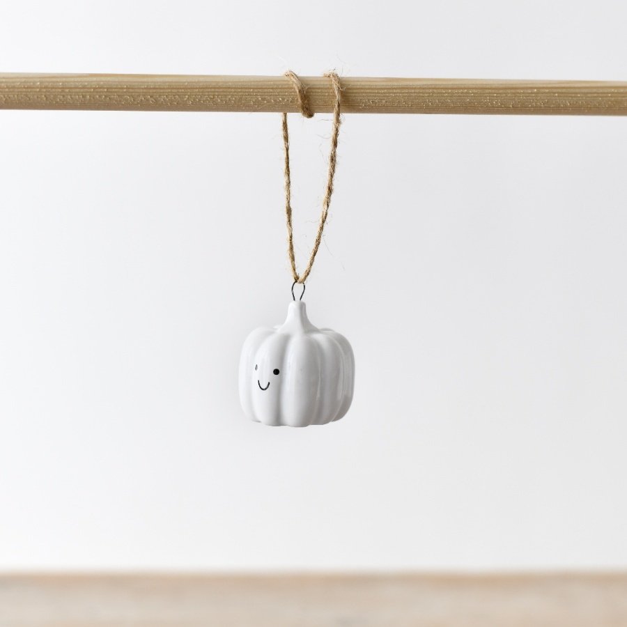 An adorable white ceramic pumpkin decoration complete with a jute string hanger.