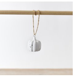 A plain white hanging ceramic pumpkin with an adorable smiley face for added charm.