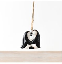 A charming pair of ceramic penguins, accompanied by a rustic jute string for easy hanging.
