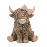 An adorable highland cow ornament featuring a dainty pink bow.