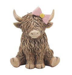 An adorable highland cow ornament featuring a dainty pink bow.