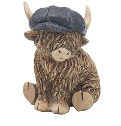 An adorable little highland cow ornament complete with a denim blue flat cap