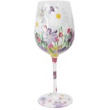 A chic wine glass featuring hand painted flowers and a greenery scene. 