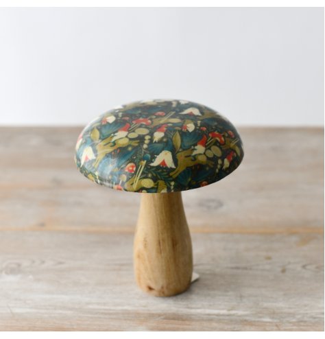 A whimsical mushroom ornament with a richly coloured enamel cap featuring gnomes, toadstools and rabbits.