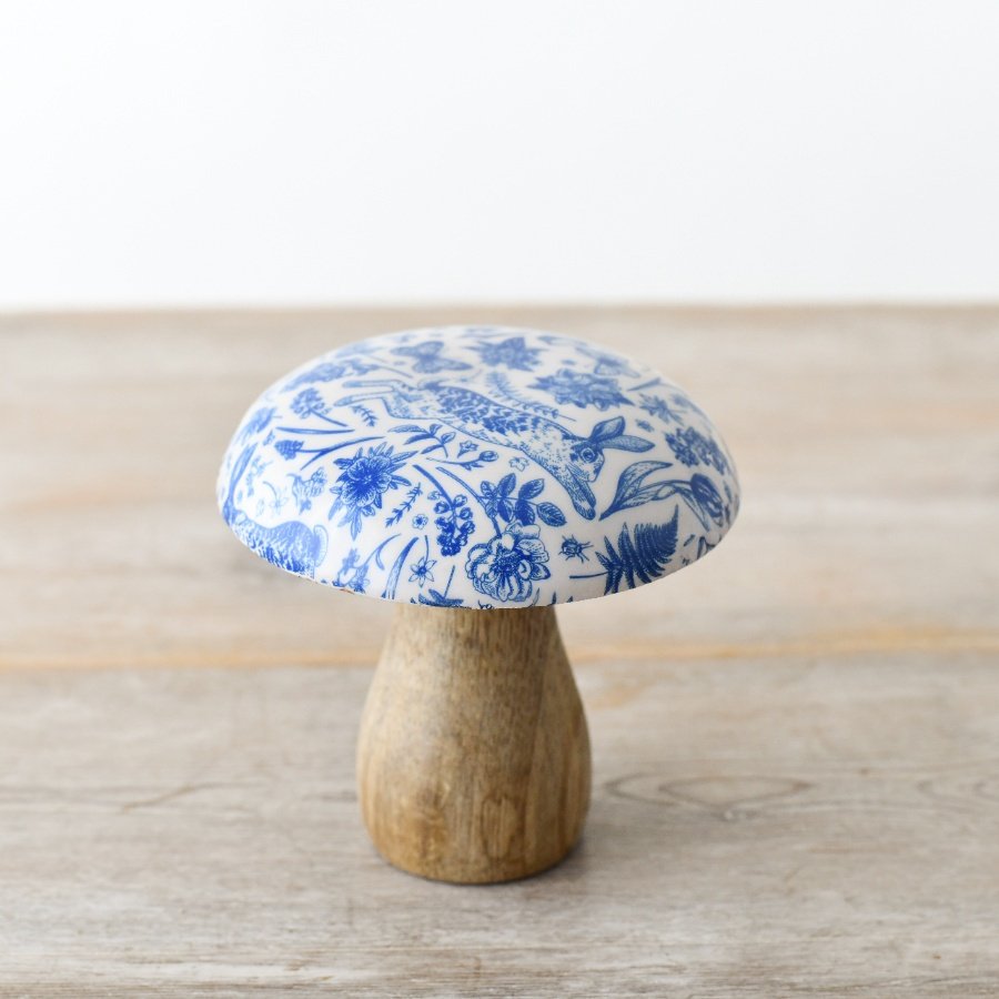 A beautifully crafted wooden mushroom with a highly decorated enamel cap.