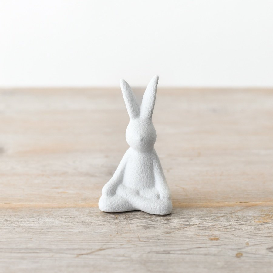 A contemporary sitting rabbit decoration with a textured, white finish. 