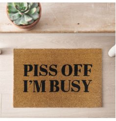 A stylish coir doormat with 'Piss off I'm busy' printed text in black. 