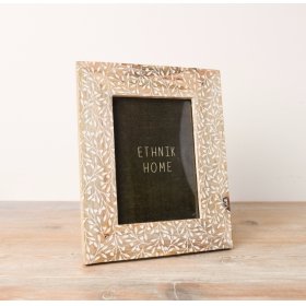 A neutral photo frame with a pretty leaf print design etched onto the front.