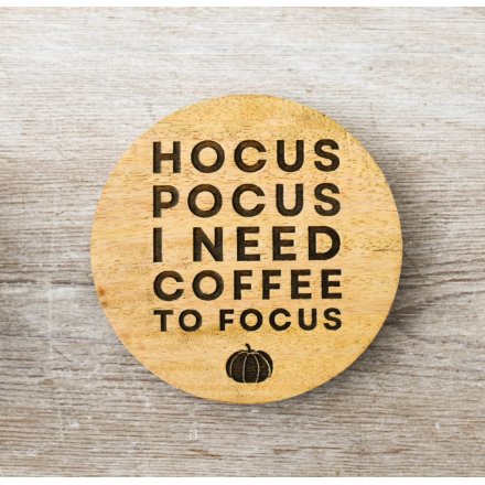A natural wood round coaster with Halloween scripted text engraved.