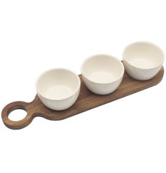 The long wooden tray features three separate bowls and dishes, making it ideal for serving a variety of snacks 