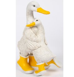An adorable pair of hugging white ducks both adorned with yellow wellies.