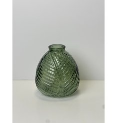 A vintage green vase displaying a leaf print design. 