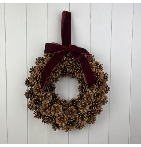 Add a touch of charm to your home this holiday with our Pinecone Wreath adorned with a festive bow. 