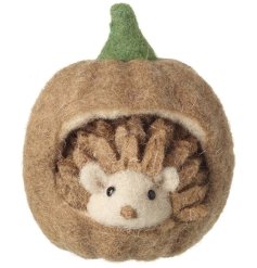 A charming felt pumpkin house with an adorable hedgehog peeping out. A unique gift and interior accessory.