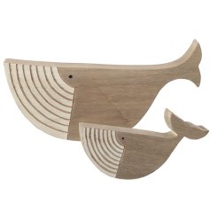 A pair of wooden whale ornaments with intricately engraved striped mouths