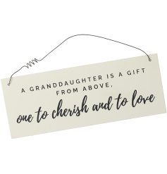 A cream wooden sign hung by wire with a loving quote devoted to a granddaughter. 