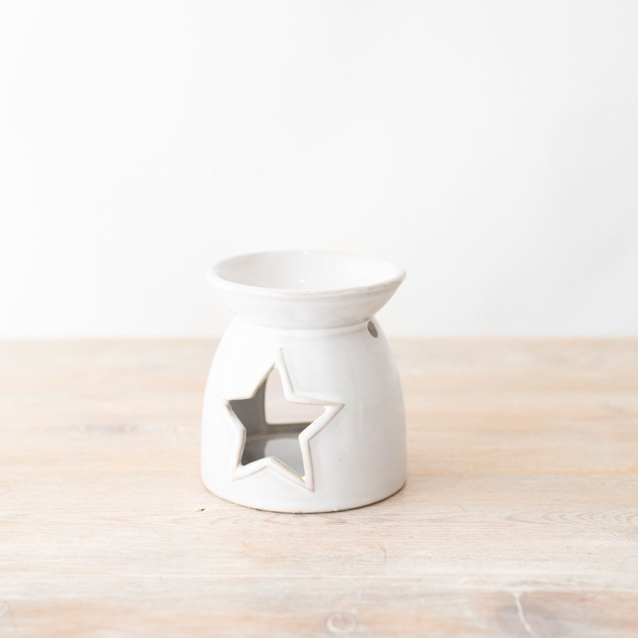 A charming oil burner in a neutral colour tone with a symmetrical star cut out at both sides.