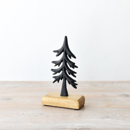 A simple black tree ornament set on a chunky wooden base.