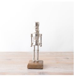 A chic silver metal nutcracker decoration with a rustic wooden base.