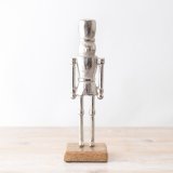 An elegant nutcracker decoration with a rustic wooden base. 