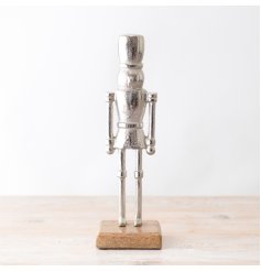 A chic silver nutcracker decoration with a rustic wooden base. The perfect seasonal accessory for the home. 
