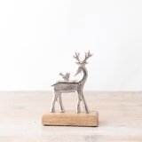 A stylish silver reindeer ornament with bird. Presented on a chunky wooden base. 