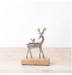 A stylish silver reindeer ornament with bird. Presented on a chunky wooden base. 