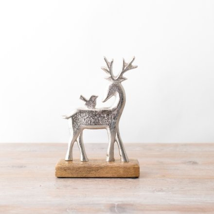 A chic silver reindeer ornament with a bird detail. Complete with a chunky rustic base.